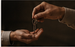 A house key being passed from one hand to another.