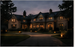 A large home at dusk with exterior lights on.